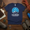 The Ascent Explore Your Peak t-shirt design featuring a circular graphic of mountains and a triangle, with text below