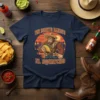 The Burrito Bandito El Squatcho t-shirt design featuring Bigfoot in a sombrero holding a taco, set against a desert sunset