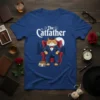 The Catfather t-shirt design featuring a cat in a suit sitting in a chair, with text and city skyline