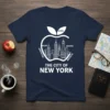 The City of New York t-shirt featuring a white outline of the NYC skyline within an apple, listing boroughs like