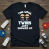 The Cool Twins Just Showed Up text with cartoon twins wearing sunglasses and capes on a black t-shirt