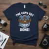Navy blue t-shirt with "THE COPS GET DONE!" text and a muscular cartoon poop character wearing sunglasses and flexing, holding