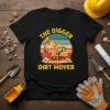 Black t-shirt with yellow text "The Digger Dirt Mover" and a graphic of an orange excavator against a sunset