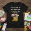 Black t-shirt with "THE FACT THAT MY KIDS NEVER THINK I'M BROKE IS VERY DISTURBING" text, a piggy bank, and