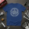 Blue t-shirt with "The Garage Is Calling And I Must Go" text and wrench graphics in a circular emblem design