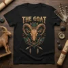 Black t-shirt featuring "THE GOAT" text above a detailed golden goat skull surrounded by green leaves and crossed arrows