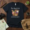 The Good Life ADVENTURE AWAITS text with a picnic basket graphic on a navy t-shirt