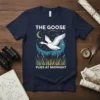 The Goose Flies At Midnight t-shirt design featuring a goose flying under a starry night sky with reeds and trees