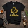 The Grillmother t-shirt design with golden crown, laurel wreath, crossed spatula and knife, and text "The Grillmother"