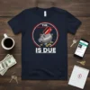 The Is Due t-shirt design with a piggy bank, credit card, and coins, conveying financial humor