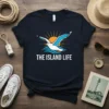 The Island Life text with a seagull flying over waves and a sun graphic on a navy blue t-shirt