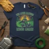 THE LAWN RANGER RIDES AGAIN text on a t-shirt featuring a man riding a lawn mower through a green field