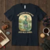 The Legendary Scottish Piper Loch Ness Sounds t-shirt design with a green dinosaur playing bagpipes in a Scottish landscape