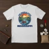 The Magnolia State Mississippi t-shirt design with a riverboat on a winding river, guitar, and sunset graphic