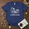 The Ocean Is Calling t-shirt with white lighthouse and wave graphic on navy blue fabric