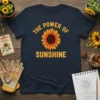 Navy t-shirt featuring "THE POWER OF SUNSHINE" text above a large sunflower graphic