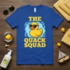 The Quack Squad text with a cartoon rubber duck wearing sunglasses in water graphic on a blue t-shirt