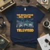 The Revolution Will Not Be Televised text on a navy t-shirt with a stylized cityscape and lightning graphic
