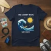 Navy t-shirt with white text "THE STARRY WAVE SURF NIGHTS" above a crashing wave and surfer graphic under a starry
