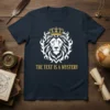 The Text Is A Mystery quote on a navy t-shirt with a white and gold lion graphic wearing a crown