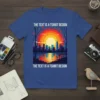 Blue t-shirt featuring the text "THE TEXT IS A TSHIRT DESIGN" above and below a colorful city skyline at sunset