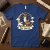 The Tortie Cat Tarot T-Shirt features a calico cat wearing a crown, surrounded by stars and clouds. The text "THE