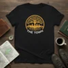 Black t-shirt with a gold tree of life logo featuring The Town skyline