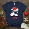 There Is Always Hope t-shirt with a silhouette figure holding a heart-shaped hot air balloon above clouds