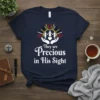 Christian t-shirt with the quote "They are Precious in His Sight" featuring hands holding a heart and three figures under