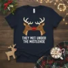 Christmas t-shirt design with text "They Met Under The Mistlehoe" above two kissing reindeer with red noses