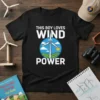 Black t-shirt with white text "THIS BOY LOVES WIND POWER" above a circular graphic of a wind turbine, green fields
