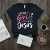 This Girl Loves Jesus text with a dove graphic on a navy blue t-shirt