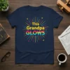 This Grandpa GLOWS text design with colorful starburst graphic on a navy t-shirt
