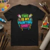Black t-shirt with colorful text reading "THIS IS MY PAINTING SHIRT" surrounded by paint buckets and brushes