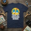 Navy t-shirt with white text "THIS JIT CRACKS BIRDS" and cartoon blue birds cracking out of eggs, representing the primary