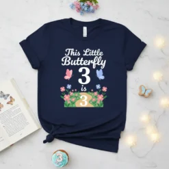 This Little Butterfly 3 is 3 design on a navy blue t-shirt, featuring white text, butterflies, and flowers with the