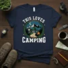 This Loves Camping t-shirt design with a motorcycle, mountains, campfire, and wreath graphic