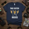 Navy t-shirt with white text "THIS SISTER ROCKS" and a graphic of a hand doing the rock horns sign inside