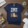 Tidy Kitty T-Shirt design featuring a cute cat sitting next to a bookshelf and a basket of yarn