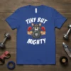 T-shirt featuring a chihuahua wearing boxing gloves and flexing muscles while holding a 200 LB kettlebell, with "TINY BUT MIGHTY"