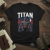 Black t-shirt featuring the word TITAN above a muscular, stone-like mythological warrior figure with mountains and a moon in the