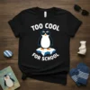Black t-shirt with "Too Cool For School" text and a penguin wearing sunglasses on an ice floe