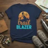 Trail Blazer T-Shirt design featuring a hiker on a mountain peak with a compass and sunset graphic