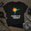 Training Is My Therapy quote on a black t-shirt with a rainbow-colored martial artist graphic in a kicking pose