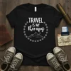 Black t-shirt with white text "TRAVEL IS MY Therapy" in a circular design with mountains and hearts