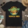 Black t-shirt with "TROPICAL VIBES" text and a graphic of palm trees on a small island at sunset