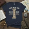 Navy t-shirt with "TRUST IN THE LORD" and Proverbs 3:5 scripture split around a stone pillar graphic