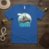 Tug Life T-Shirt featuring a cartoon tugboat in the water with city skyline behind, text "TUG LIFE" below