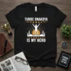 Black t-shirt with "Tunde Onakoya Is My Hero" text, silhouette of a person raising arms on a pedestal, stars, and