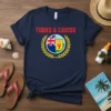 Navy blue t-shirt with "TURKS & CAICOS" in red text above a circular emblem featuring the Union Jack and island